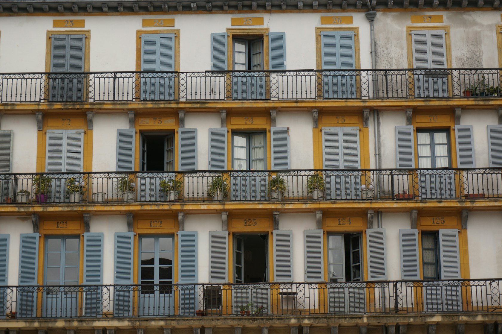 Fachada de edificio residencial con contraventanas azules y balcones en San Sebastián