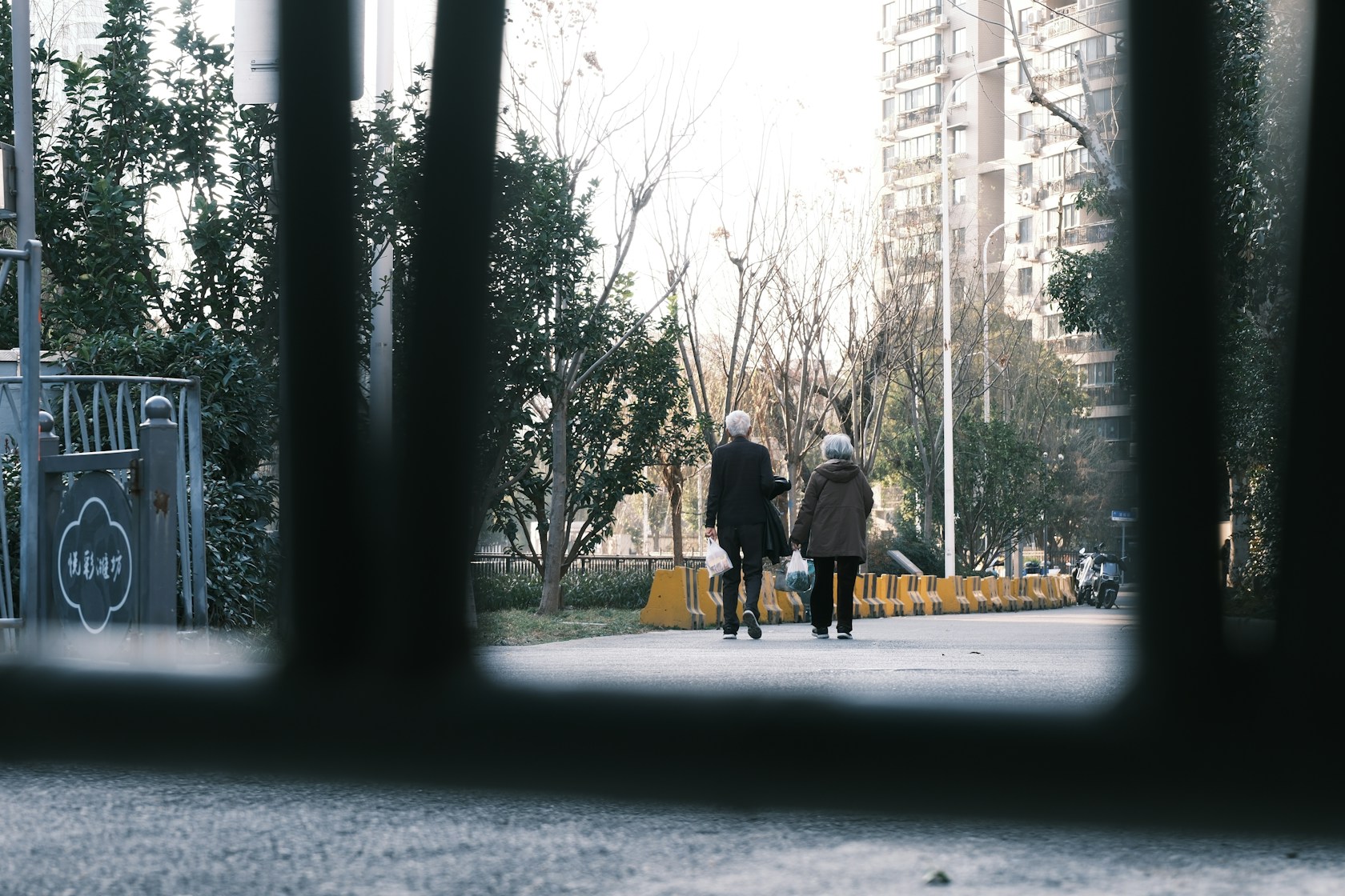 Pareja de personas mayores paseando de la mano por un camino urbano tranquilo