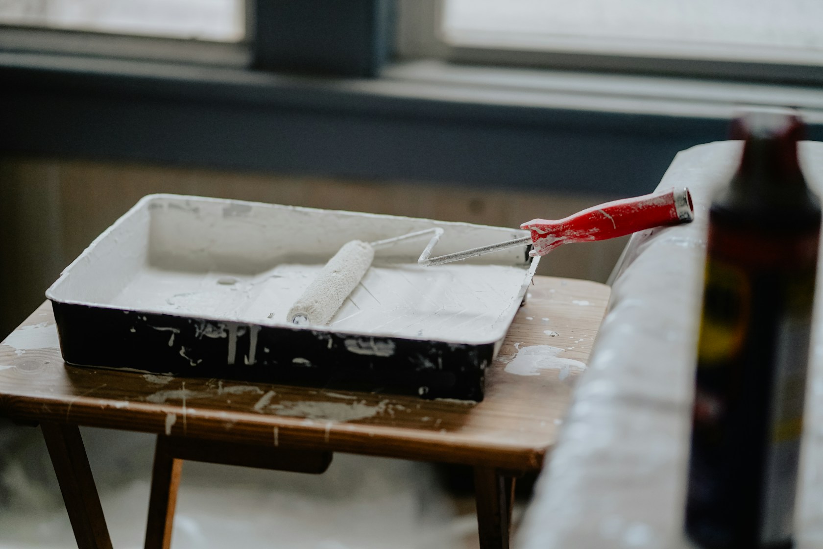 Ampliar hipoteca para reformar la vivienda: rodillo y bandeja de pintura durante una obra en casa