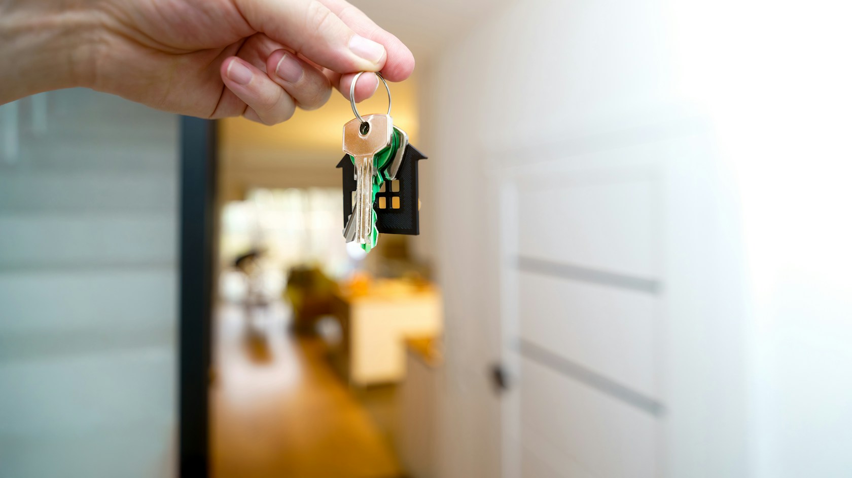 Cómo conseguir hipoteca: mano sosteniendo las llaves de una nueva vivienda en el recibidor