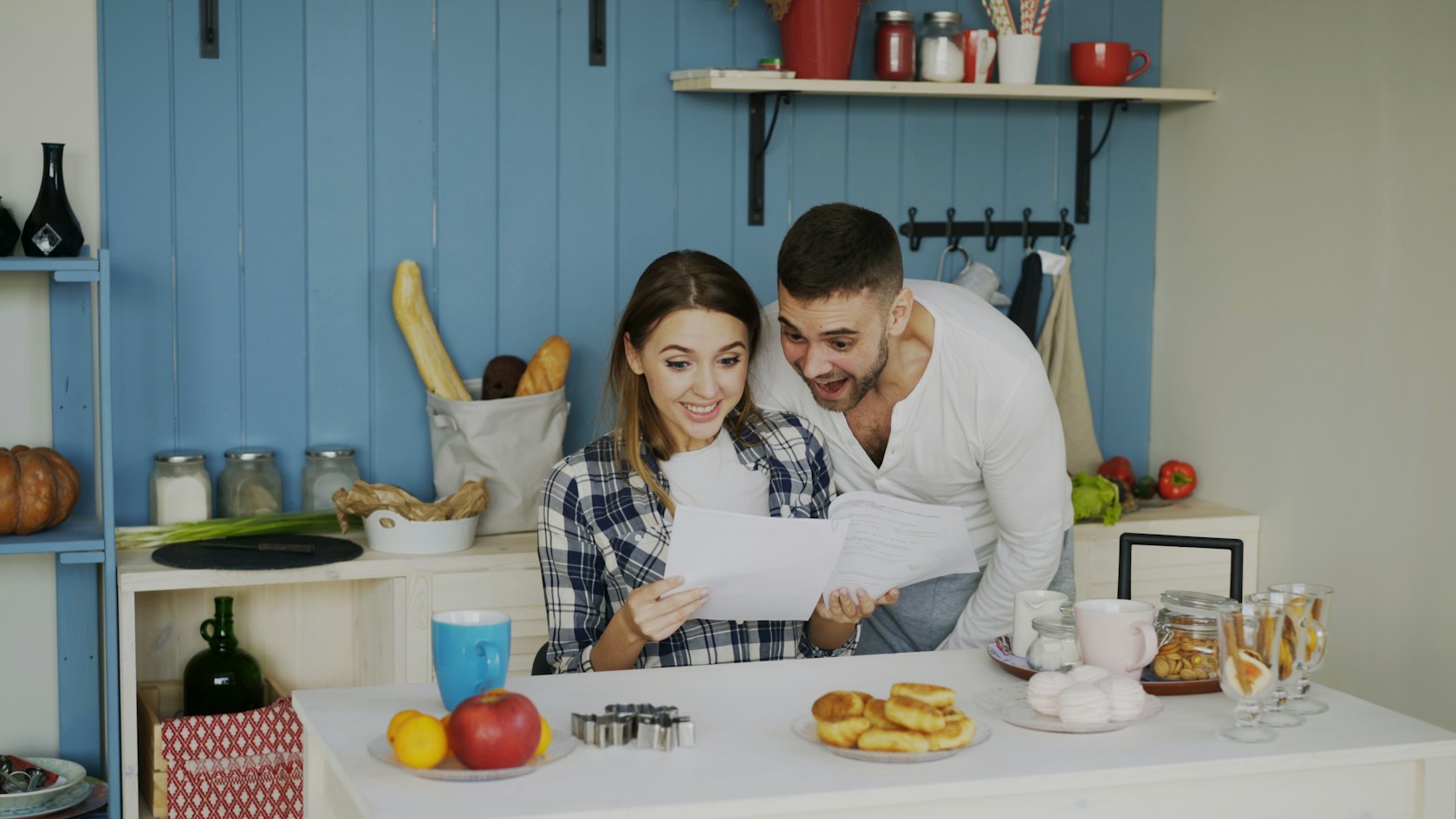 Pasar hipoteca variable a fija: pareja revisando en la cocina la oferta de su banco